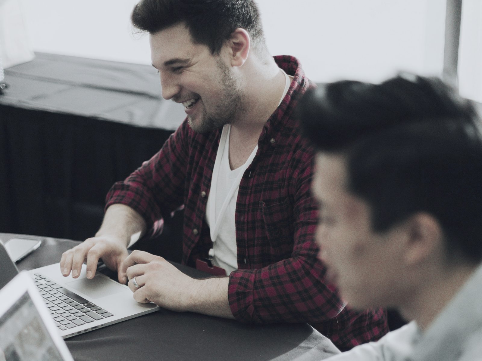 Twee mannen aan tafel met laptops